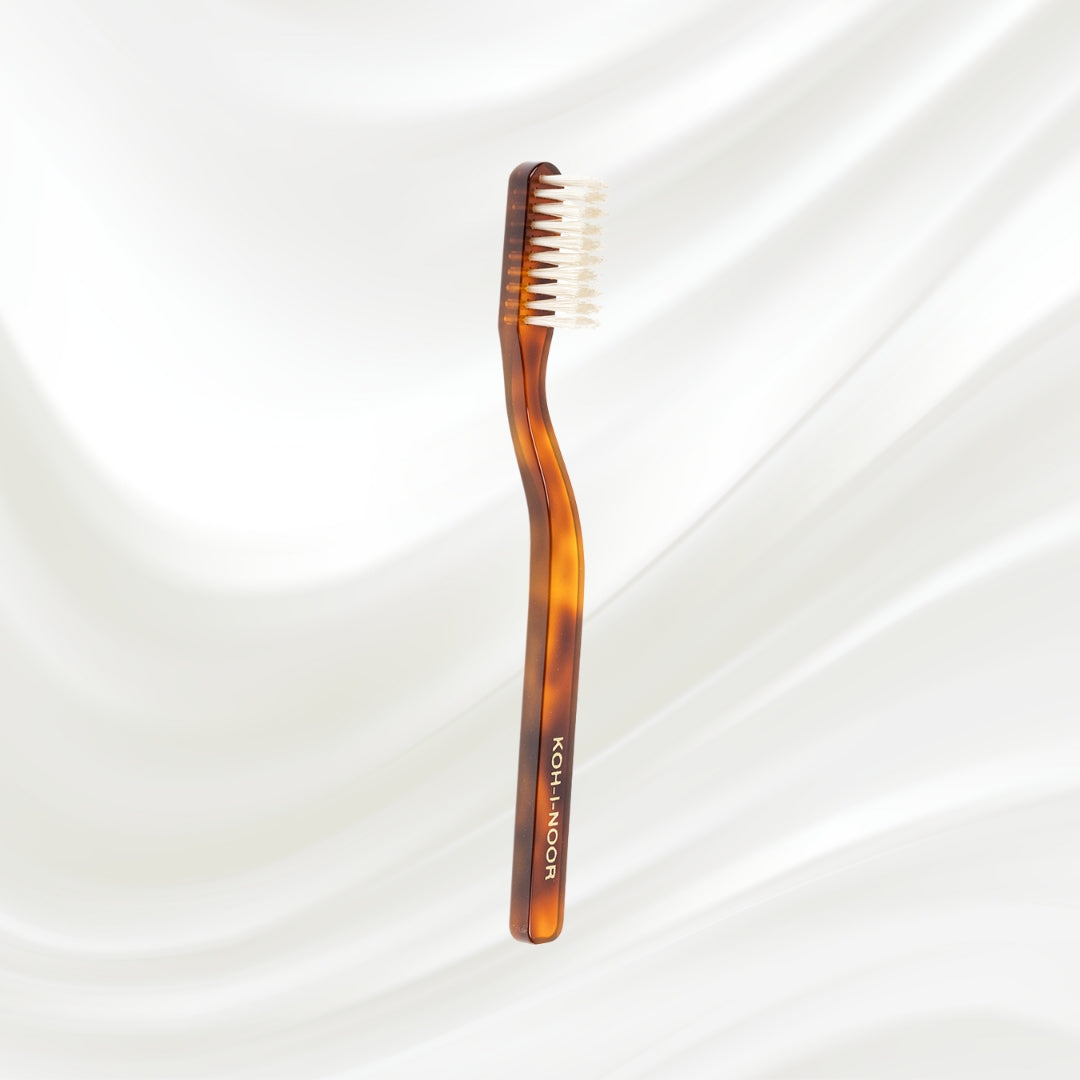 Tortoiseshell toothbrush with 'Koh-I-Noor' branding on a white background