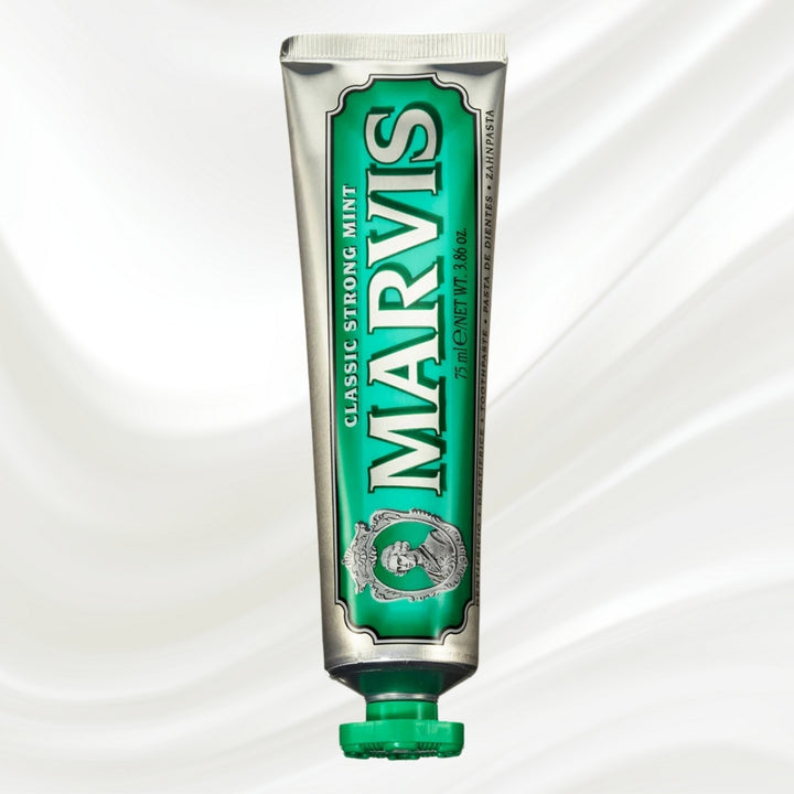Green tube of Marvis toothpaste on a white background