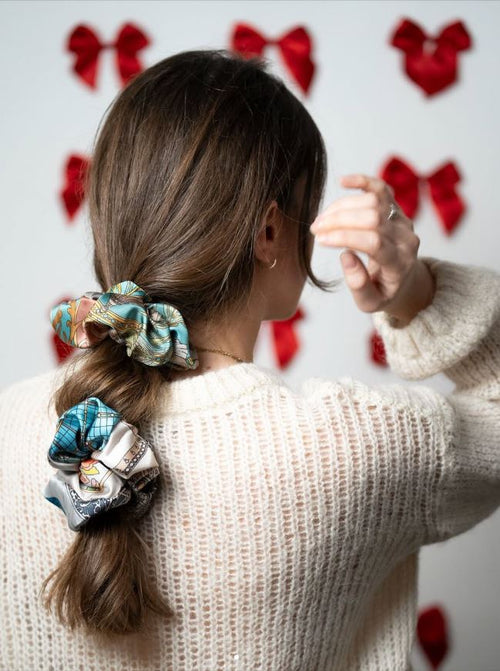 brunette girl viewed from the back, with two silk scrunchies on her hair
